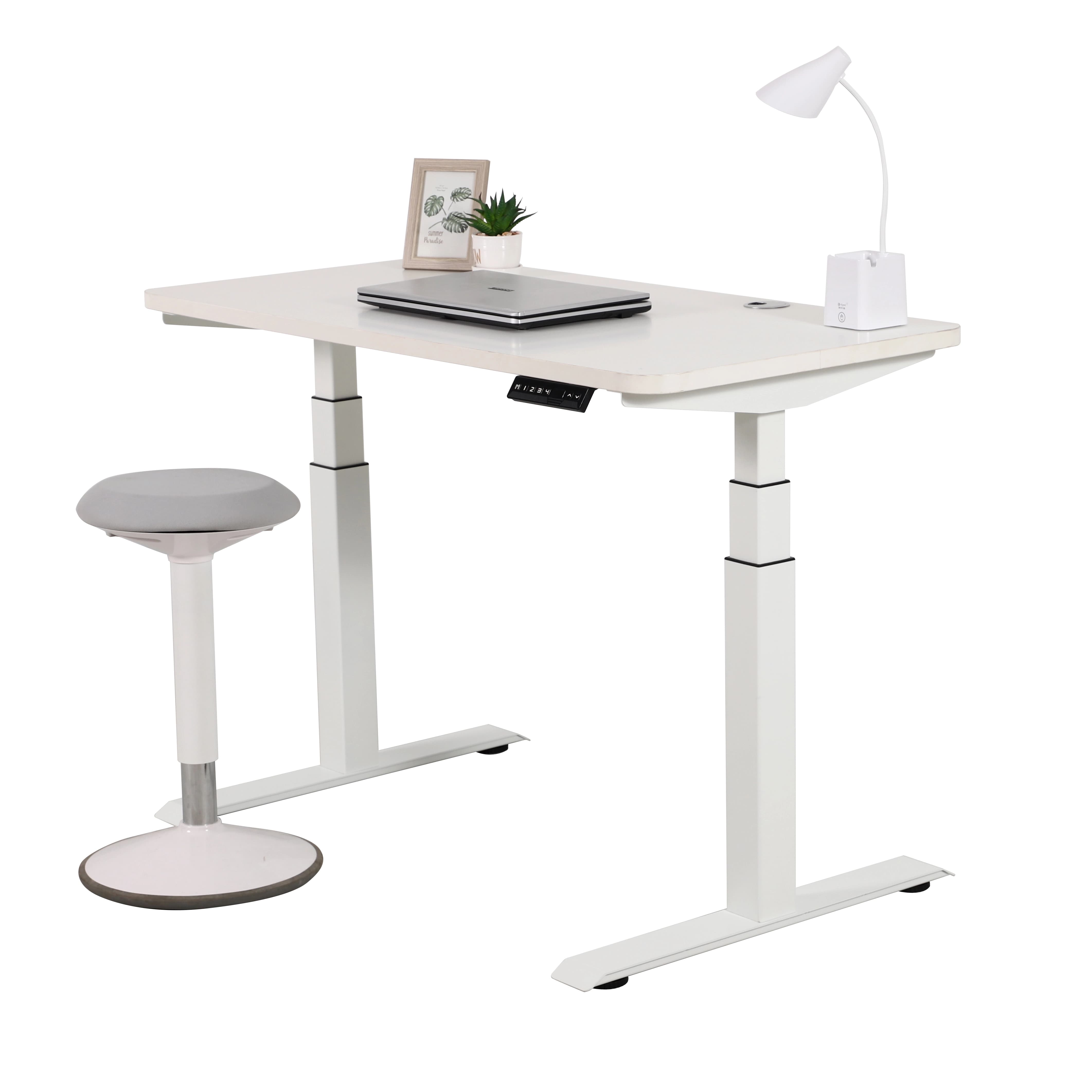 Ein wei&szlig;er 2B3 verstellbarer Stehschreibtisch mit wei&szlig;er Tischplatte, ausgestattet mit einem Laptop, einer kleinen Pflanze und einer Schreibtischlampe. Neben dem Schreibtisch steht ein grau-wei&szlig;er ergonomischer Hocker vor einem wei&szlig;en Hintergrund.